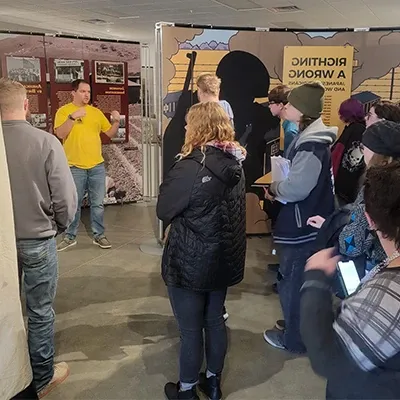 a presenter talks to a crowd at an exhibit