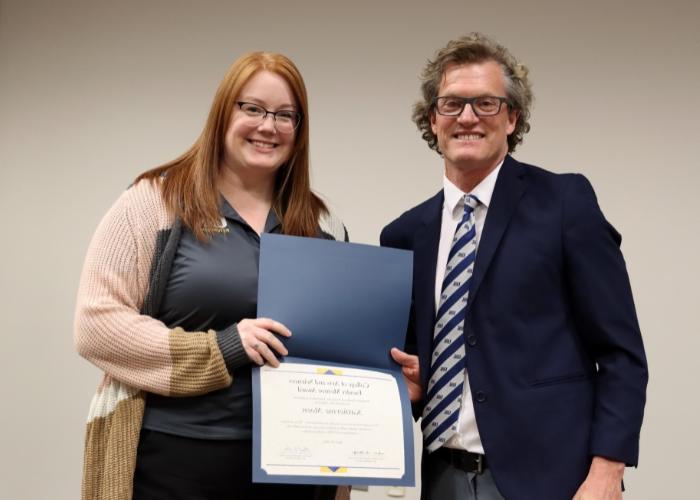 A man presenting an award to a woman.