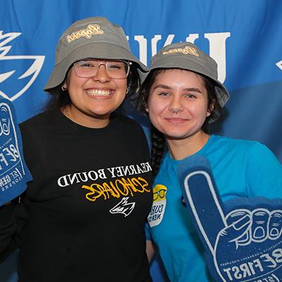 Students pose for a photo holding foam fingers